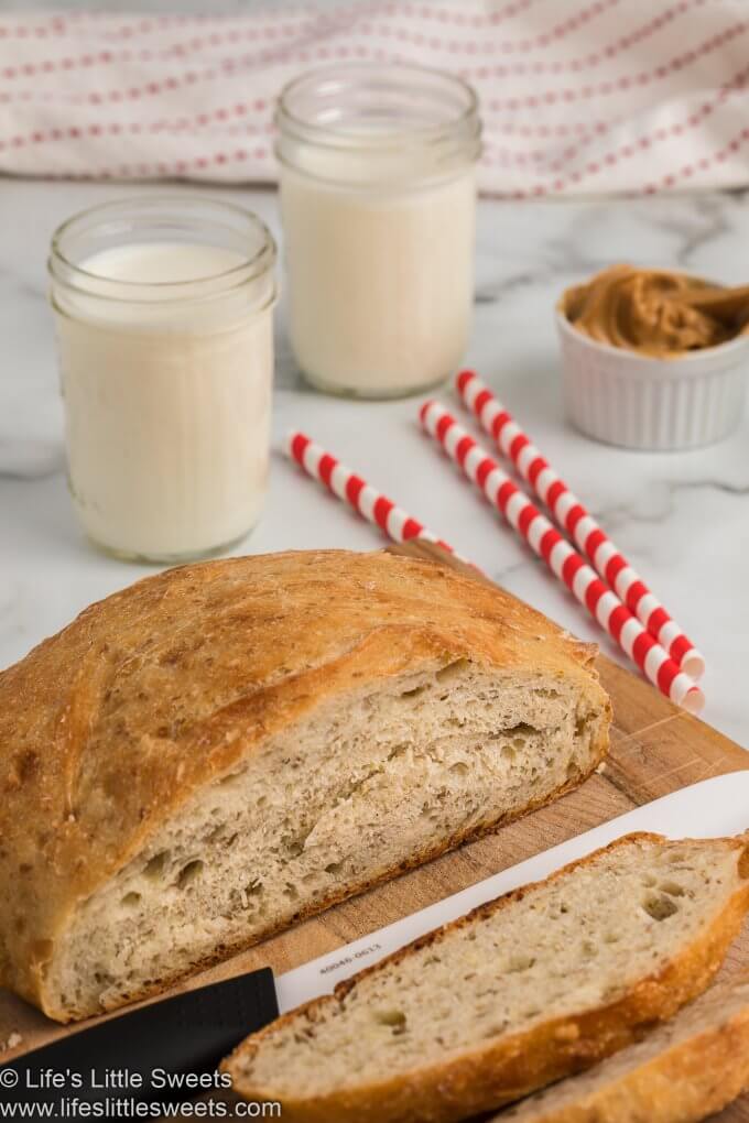 No-Knead Flaxseed Bread with milk sliced on a white marble countertop