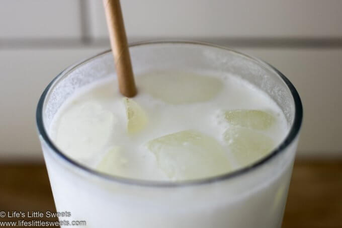 Milk in a glass with a paper straw