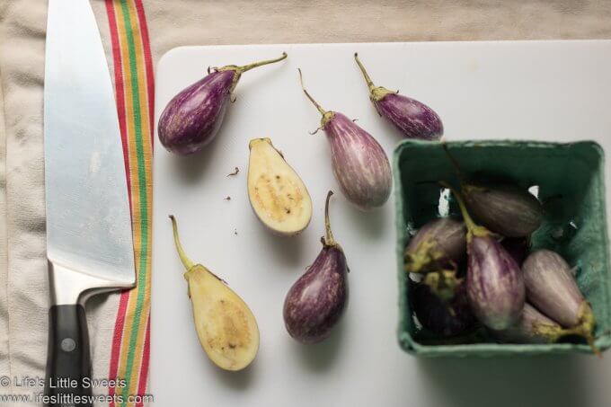 fresh purple striated Fairytale eggplants on a cutting board