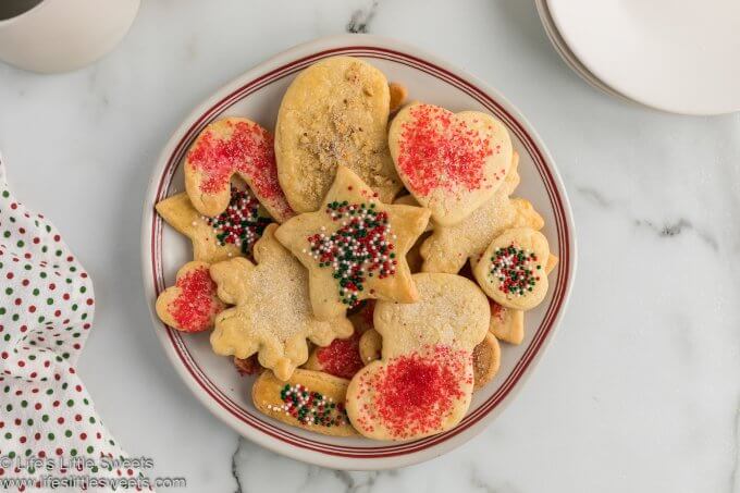 overhead view of decorated sand tarts in a bowl with red and Christmas colored sprinkles 