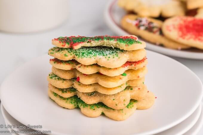 a stack of sand tart cookies and one on top with a bite taken out