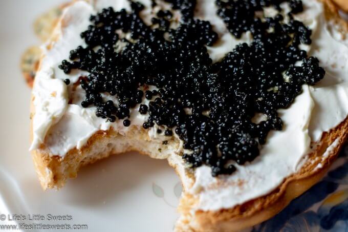 Caviar Cream Cheese Bagel in a white kitchen with a bite