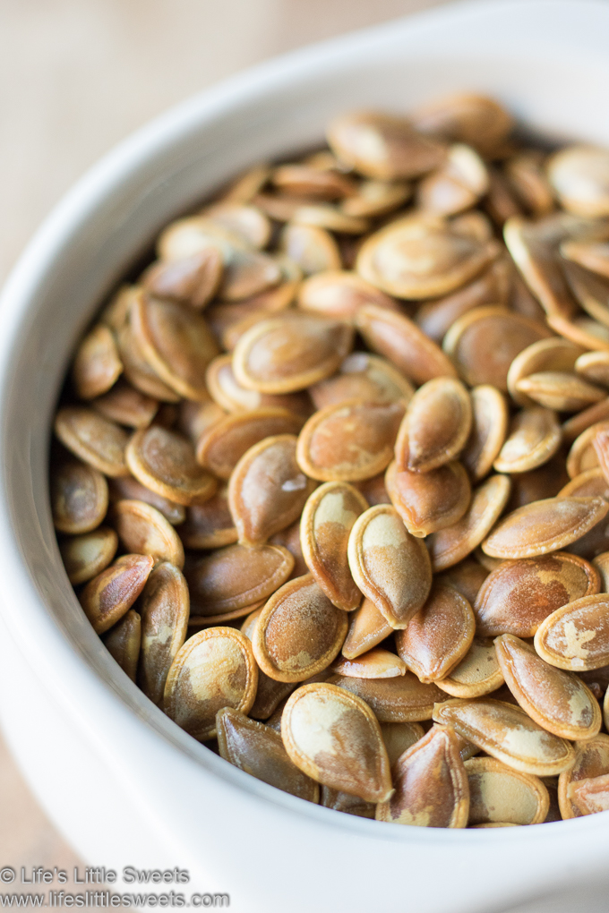 Roasted Pumpkin Seeds close up in a white crock bowl