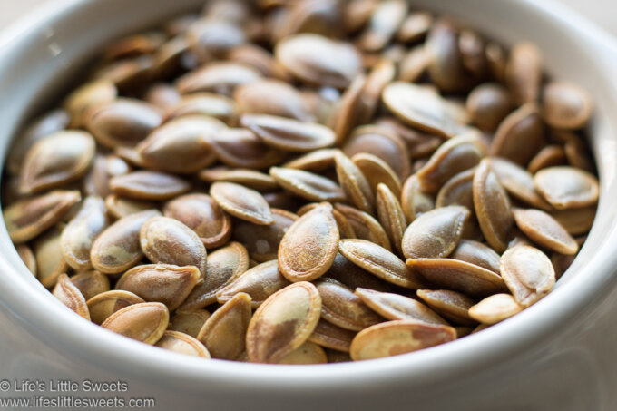 Roasted Pumpkin Seeds close up in a white crock bowl