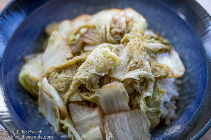 Stir-Fried Napa Cabbage in a blue bowl over steamed rice with white pepper