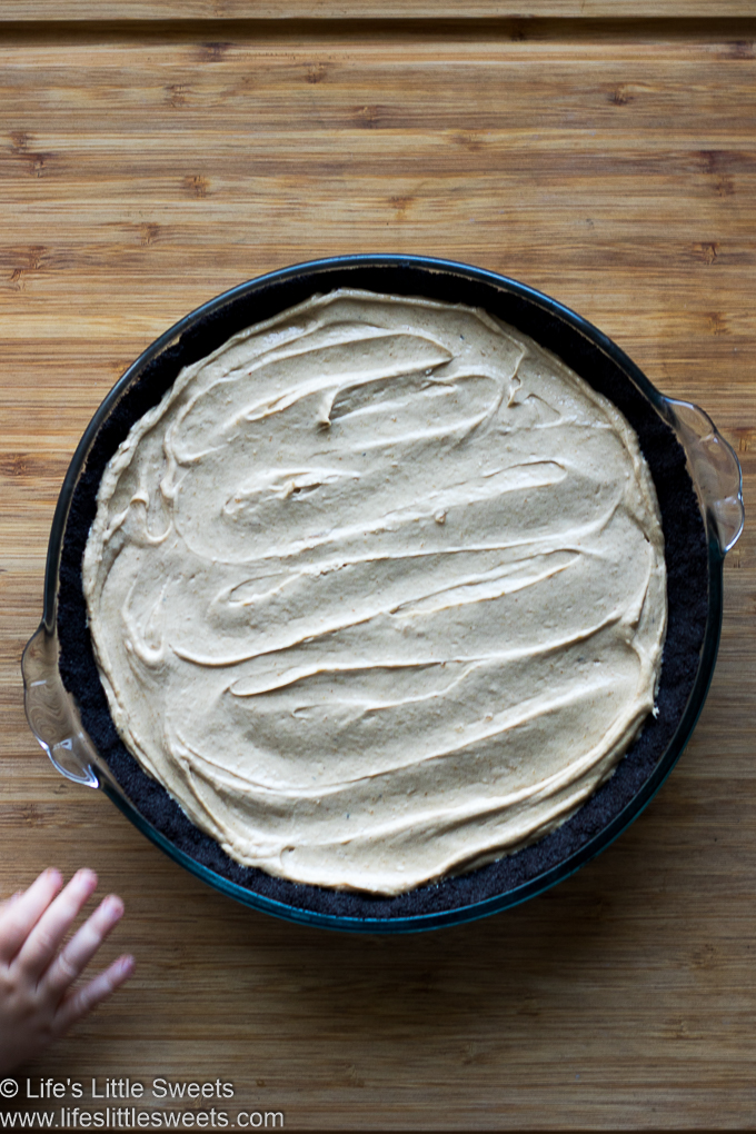 and overhead view of a chocolate wafer cookie crust pie with a hand reaching for it