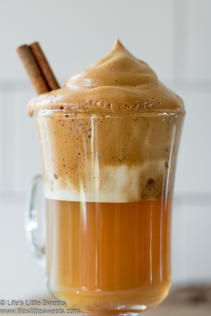 Apple Cider Whipped Coffee close up with cinnamon stick with bubbles in the foam