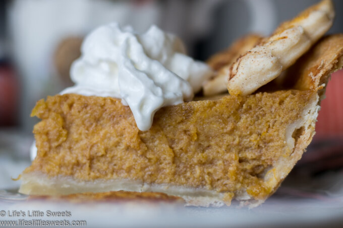Up close view of pumpkin pie with whipped cream