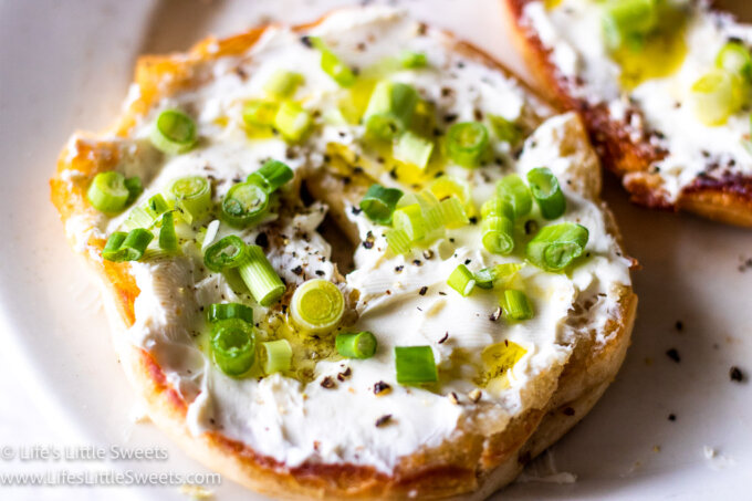 Bagel with Cream Cheese and Scallions on a white plate