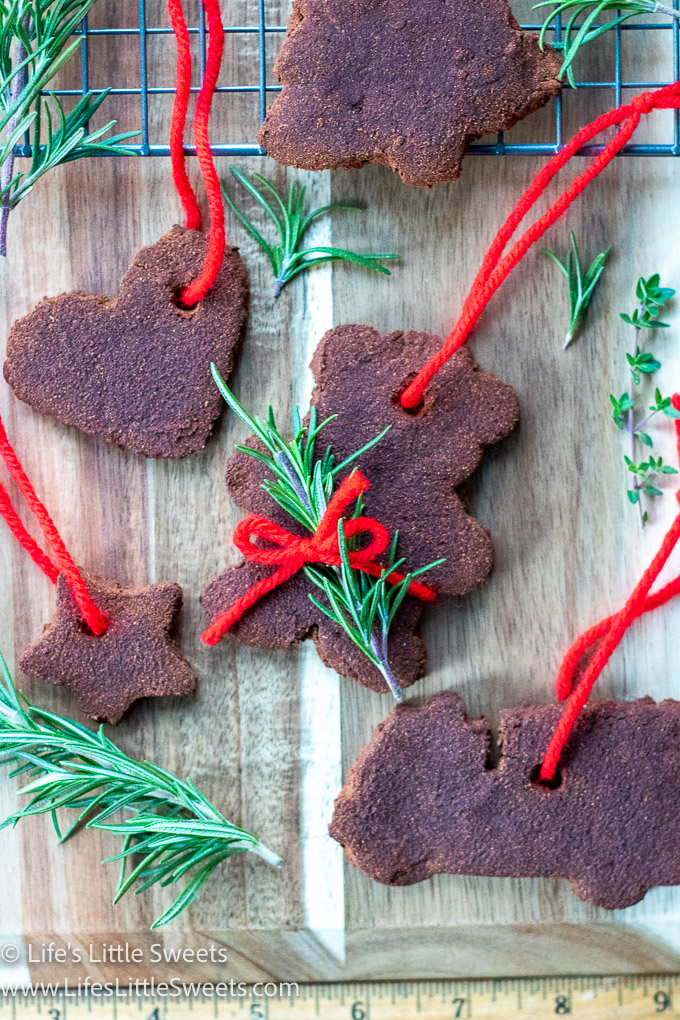 Cinnamon Applesauce Ornaments with red yard string and rosemary garnish