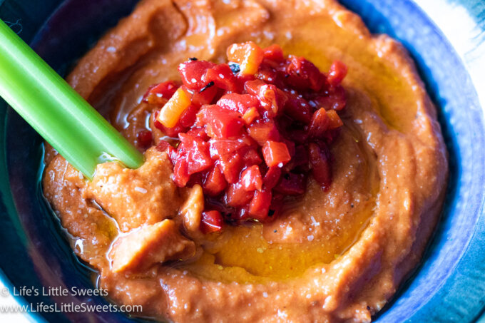 close up of roasted red pepper hummus in a blue bowl