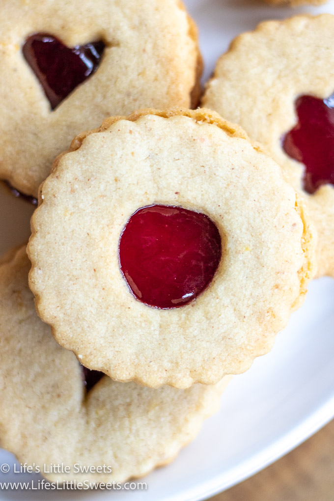 Linzer Cookies on a white plate with red jam