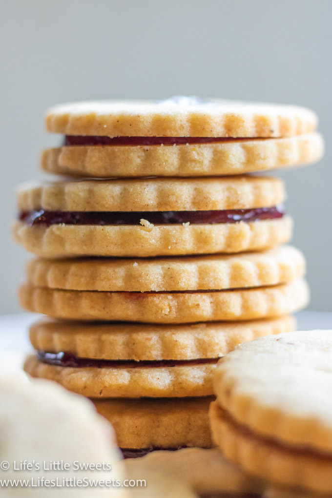 a stack of Linzer cookies with red jam