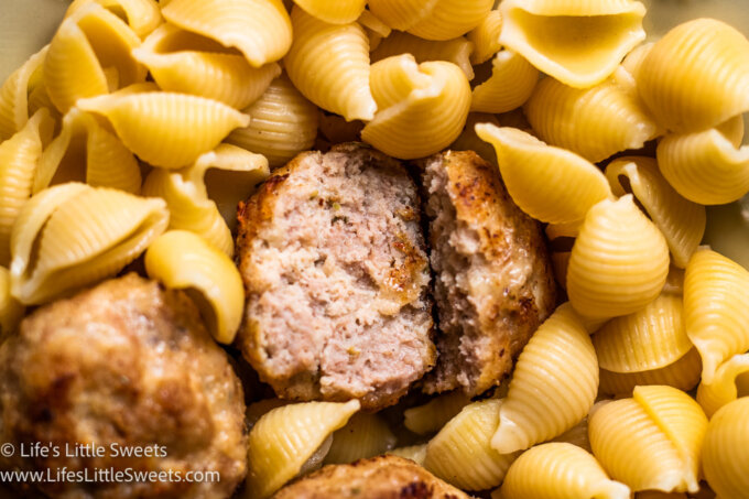 a meatball cut in half with pasta shells