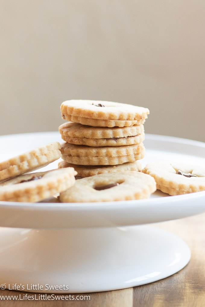 Nutella Linzer Cookies on a white cake stand