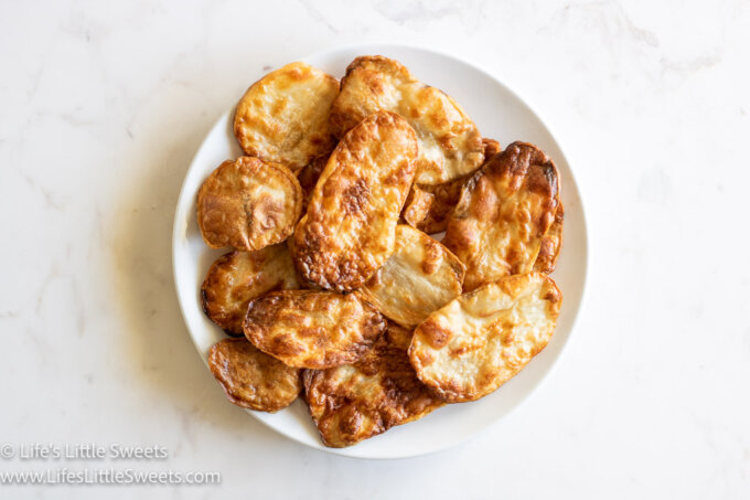 Air Fryer Potato Chips on a white plate on a white marble countertop horizontal view