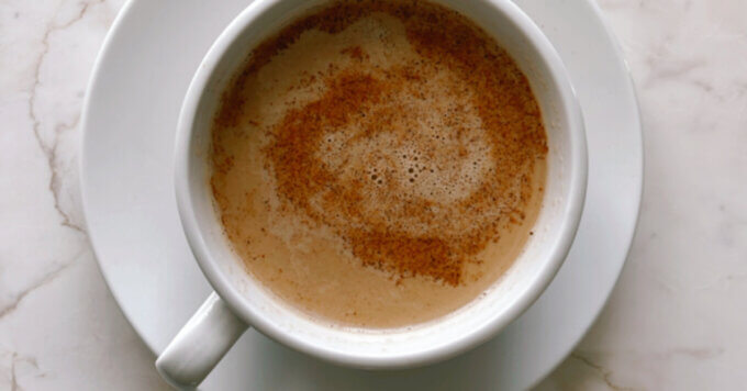 Café au Lait drink close up with cinnamon in a white mug horizontal photo