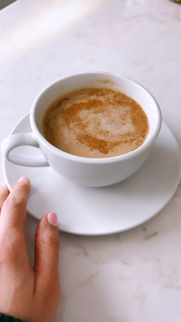 Café au Lait drink close up with cinnamon in a white mug side view