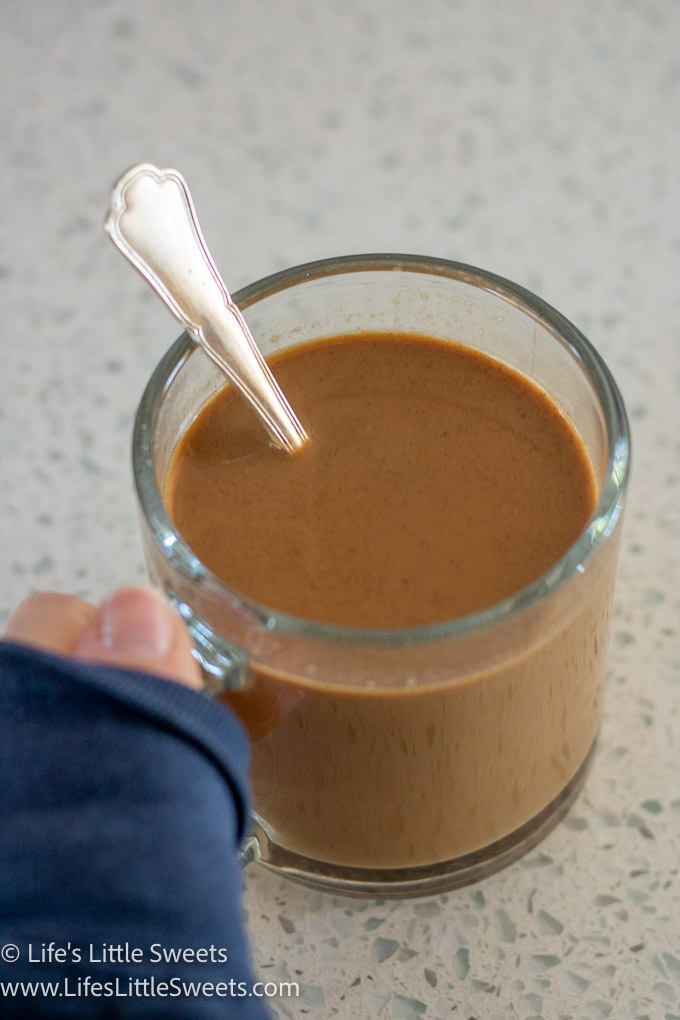 a hand holding a mug of hot coffee