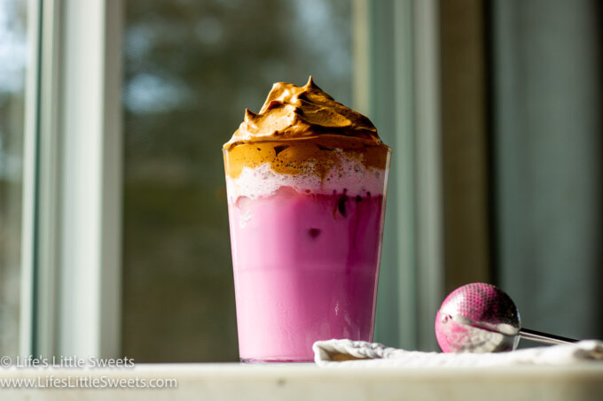 Dragon Fruit Whipped Coffee on a marble countertop with a window behind