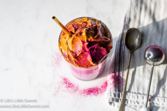 Dragon Fruit Whipped Coffee on a white marble countertop and a gold straw overhead view