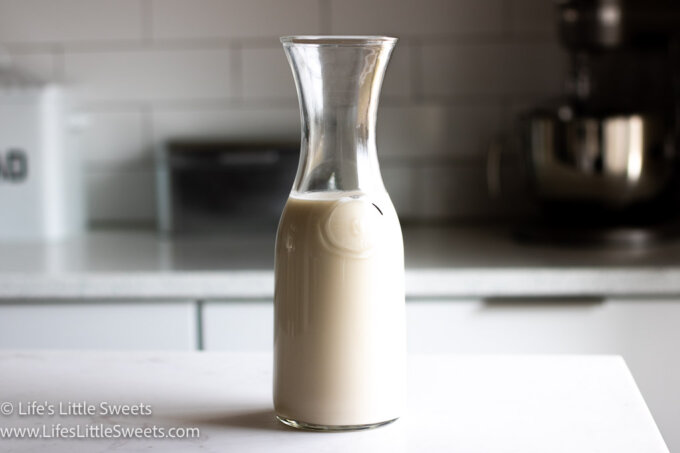 homemade oat milk in a glass bottle in a white kitchen