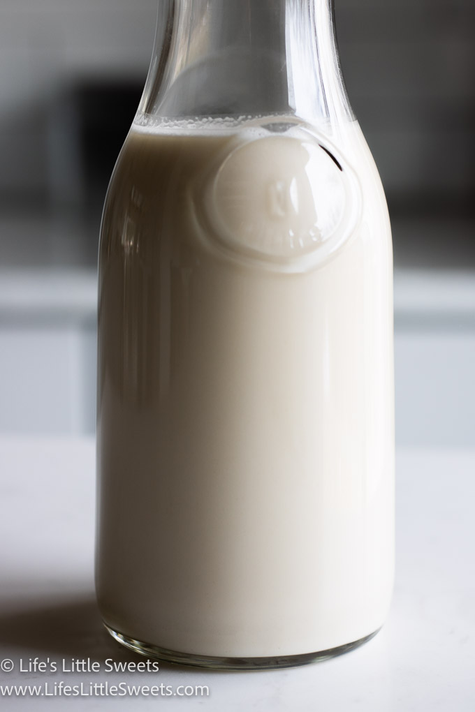 close up of a milk bottle with white homemade oat milk