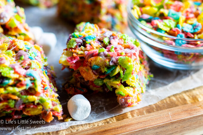 colorful rice cereal treats on a wood board