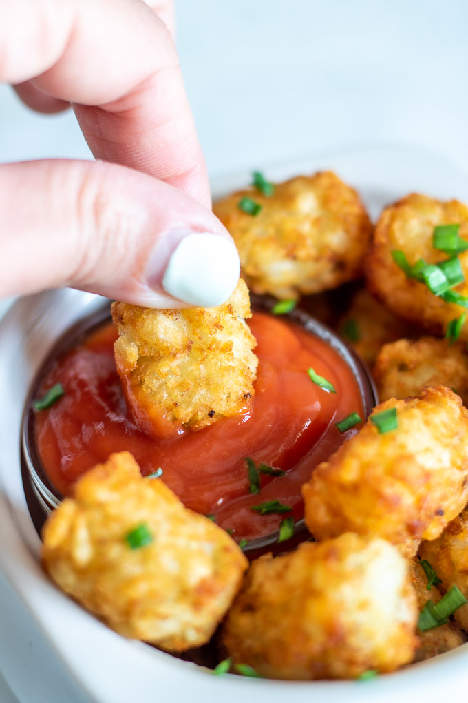 tater tot being dipped into ketchup