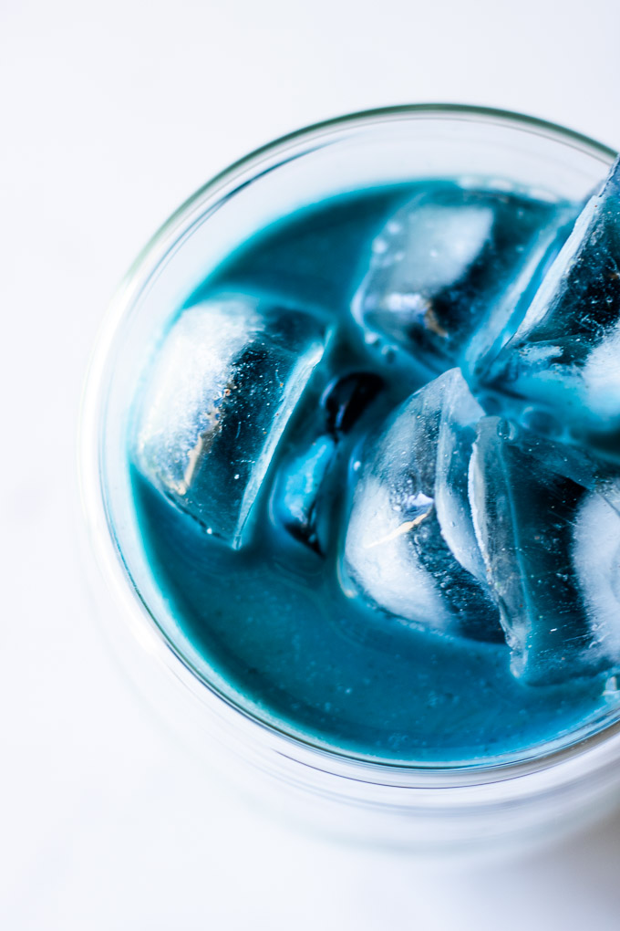 Butterfly Pea Flower Milk Tea overhead with ice on a white marble countertop