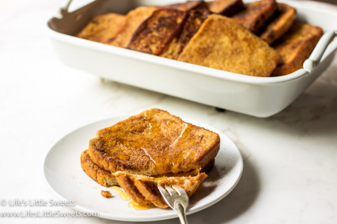 a platter of French toast in a white marble kitchen with more french toast on a plate and a fork