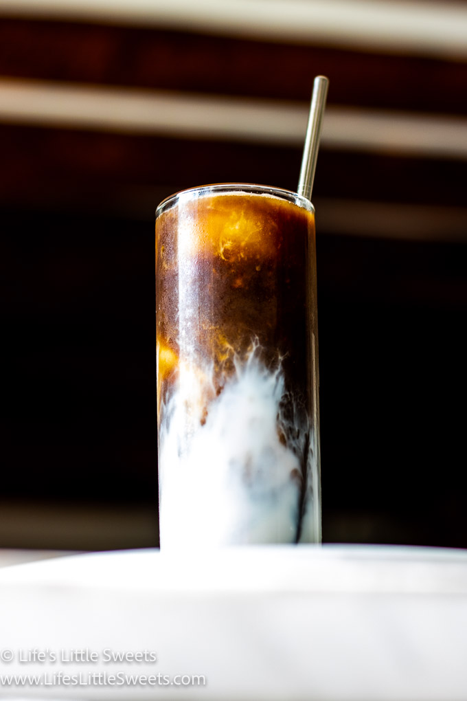 Iced Coffee with Almond Milk on a marble counter in a kitchen with big wood beams