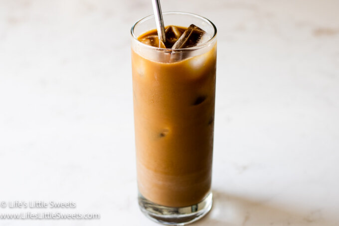 Iced Coffee with Almond Milk on a marble counter with a stainless steel straw stirred together