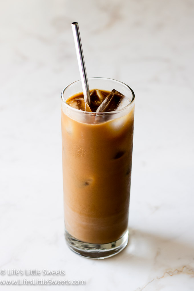 Iced Coffee with Almond Milk on a marble counter with a stainless steel straw