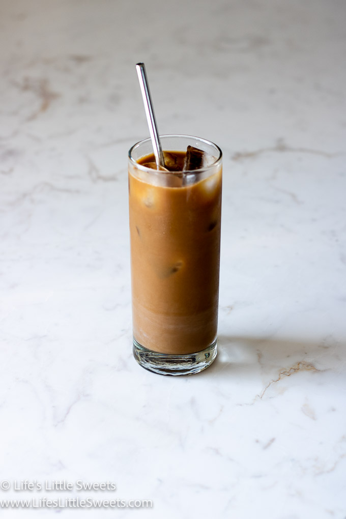 Iced Coffee with Almond Milk on a marble counter with a stainless steel straw