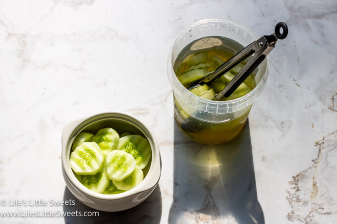 Cucumbers in Pickle Juice in 2 containers with tong in 1 container