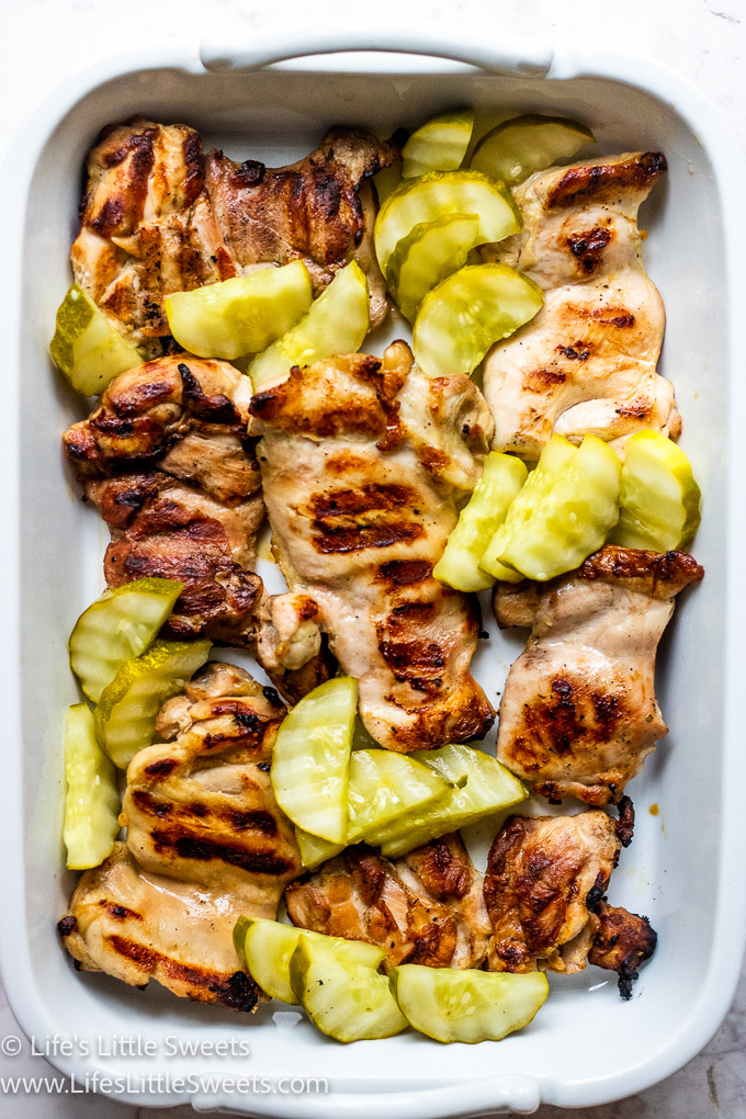 green pickles with grilled chicken in a white dish close up