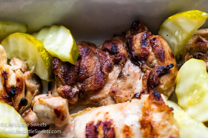 green pickles with grilled chicken in a white dish up close