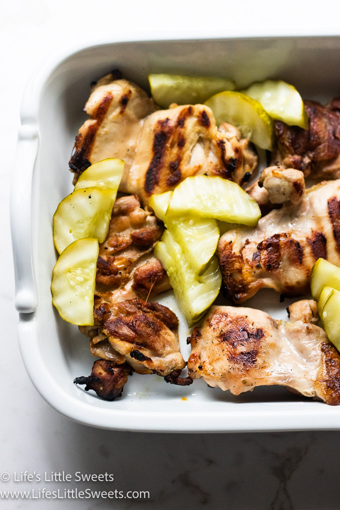 chicken in white dish with pickles