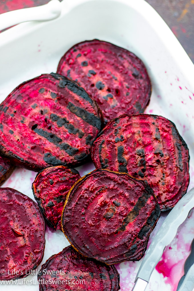 red Grilled Beets in a white serving platter on a red metal table
