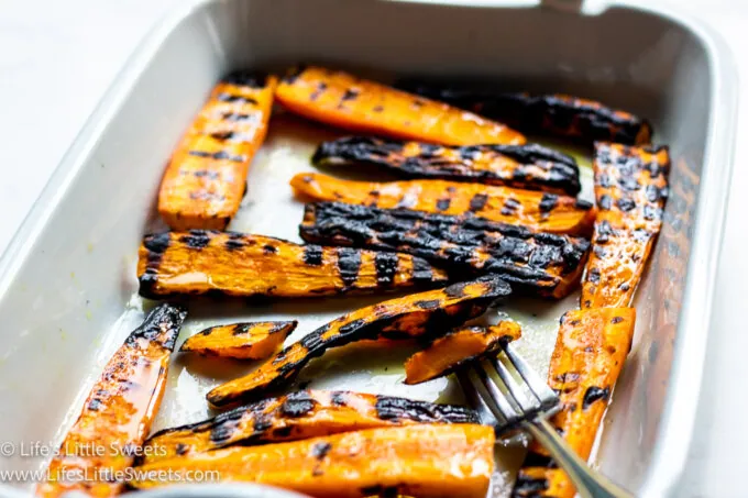 grilled carrots in a white dish with a fork