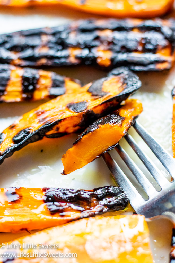 close up view of grilled carrots with a fork