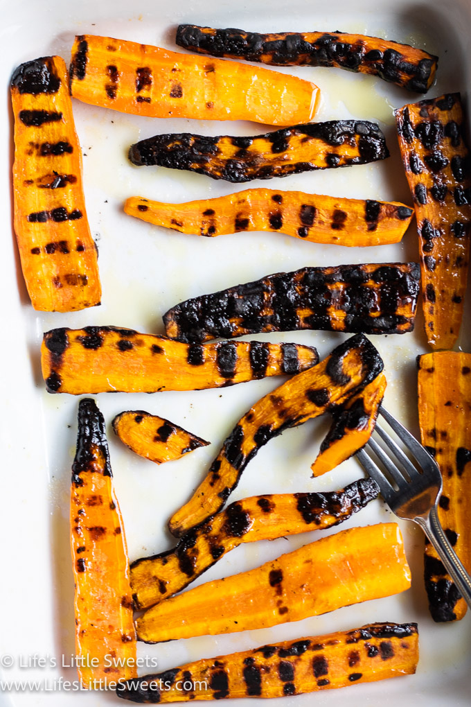 grilled carrots in a white dish with a fork