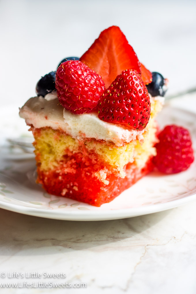 a 9x13-inch pan of cake with berries with a slice of cake on a plate