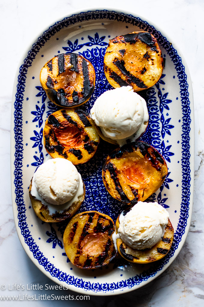 Grilled peaches with vanilla ice cream over a white marble countertop