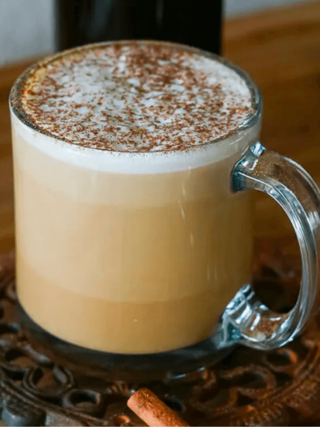 a hot, coffee recipe on a wooden surface in a clear mug
