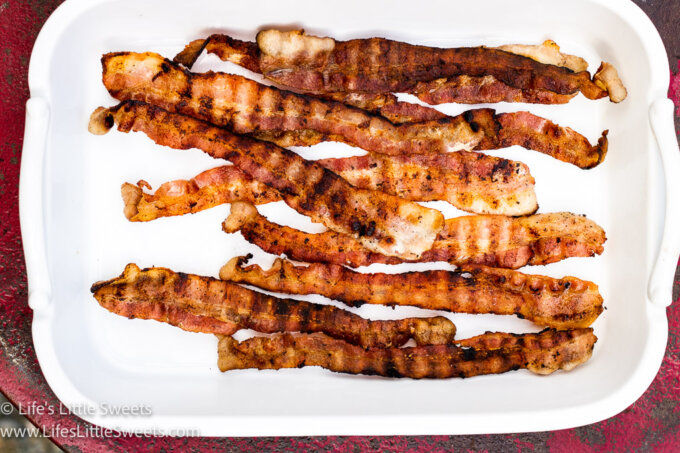 piles of grilled bacon on a rectangular white platter