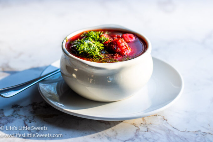 red Borscht soup with dill and sour cream on a marble countertop