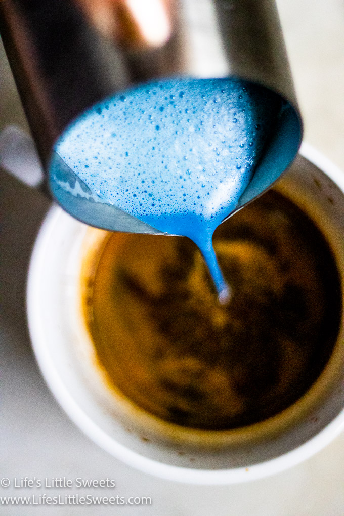 a blue frothy milk and espresso drink in a white mug