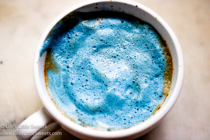blue frothy espresso drink in a white mug